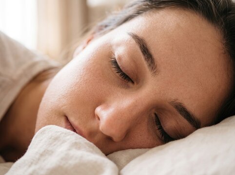 Close-up portrait of a peaceful young woman sleeping soundly in a bed with peaceful sleep