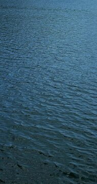 Blue water texture from real camera. Water surface glides under daylight, showing soft texture, depth, and tranquil natural feeling.