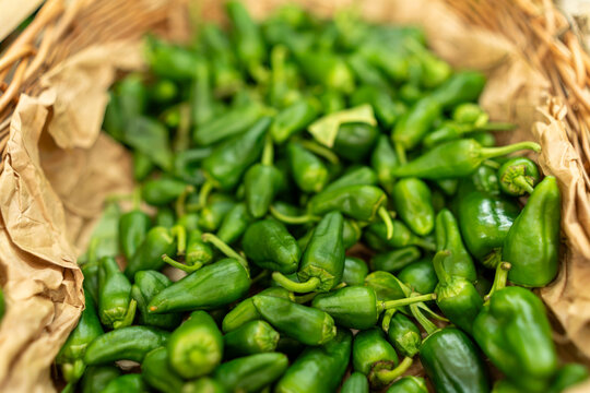 Padron peppers filling a basket with brown paper, showcasing fresh organic produce from a market