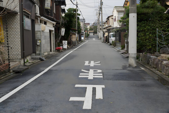 JAPAN - JANUARY 6, 2014: Quiet residential street with Japanese stop mark on asphalt road.