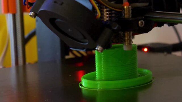 A video showcasing a 3D printer creating a green plastic object