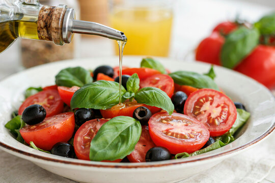Fresh caprese salad with cherry tomatoes and basil drizzled with olive oil