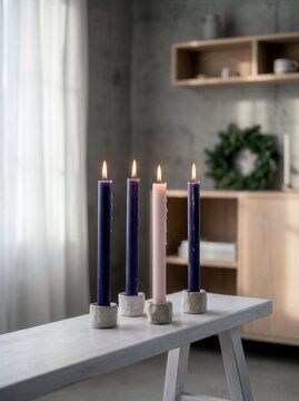 Advent candles stand aligned on a white bench inside a bright modern living room.
