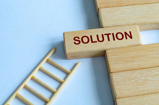 Wooden blocks with ladder representing progress toward solutions, goals, and successful outcomes.