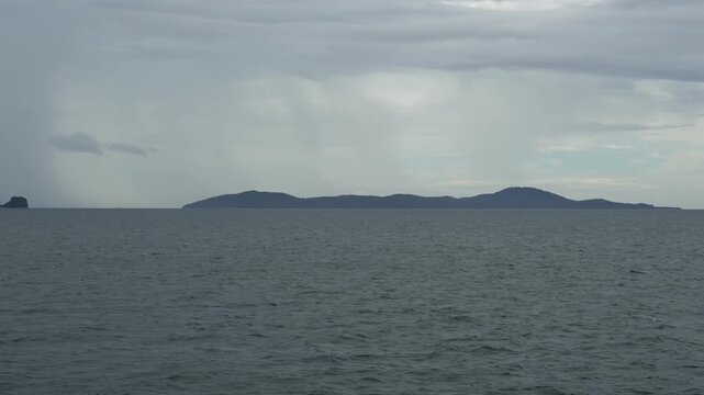 View from a ferry crossing the Gulf of Thailand toward Koh Samui with Mu Ko Ang Thong National Marine Park islands visible in the background under heavy monsoon in Surat Thani, Thailand