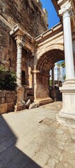 Obraz premium Vertical view of the ancient Roman Hadrian's Gate left arch in Antalya, Turkey. Distant shot of historic marble architecture in Kaleici.