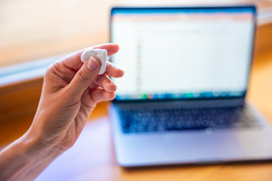 Woman squeezing stress relief putty while working at laptop. Sensory hand exercise helps reduce tension and manage stress during computer work