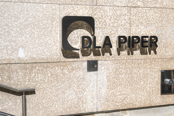 Fototapeta premium Toronto, Ontario, Canada - October 6, 2025: DLA Piper (Canada) law firm logo sign at the entrance to the office in downtown Toronto, Ontario, Canada. DLA Piper is a global law firm. 