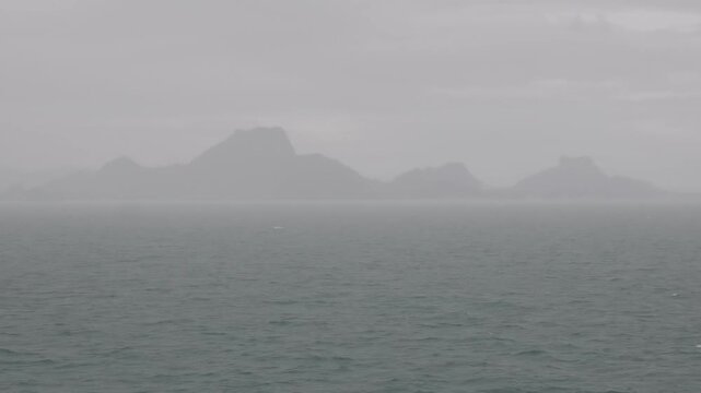 View from a ferry crossing the Gulf of Thailand toward Koh Samui with Mu Ko Ang Thong National Marine Park islands visible in the background under heavy monsoon in Surat Thani, Thailand