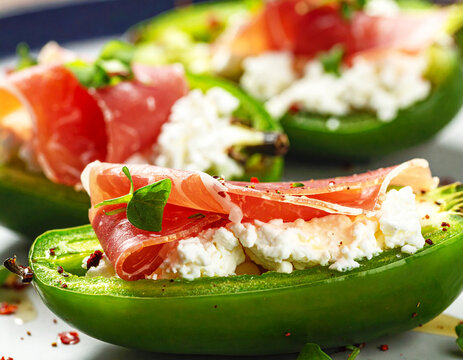 Jalapeno peppers stuffed with cream cheese and prosciutto, macro shot. AI