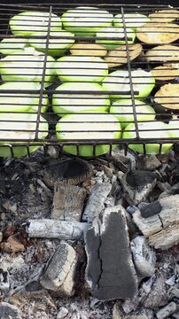 Grilling sliced vegetables on the barbecue at a backyard gathering in summer