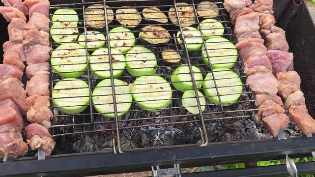 Grilling meat and vegetables on a barbecue grill with an open flame