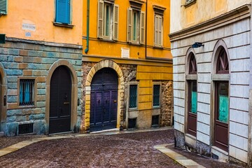 Fototapeta premium Cobblestone alley between colorful buildings