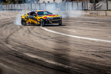 Drifting sports car creating smoke and tire marks on asphalt track © shine.graphics