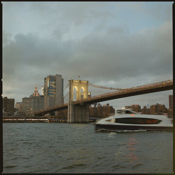 Brooklyn Bridge and ferry at dusk