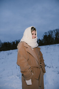 Woman in Winter Coat and Knit Scarf Standing in Snowy Landscape