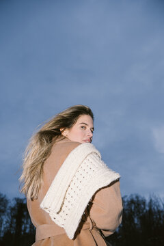 Woman Looking Over Her Shoulder in Winter Coat and Knitted Scarf