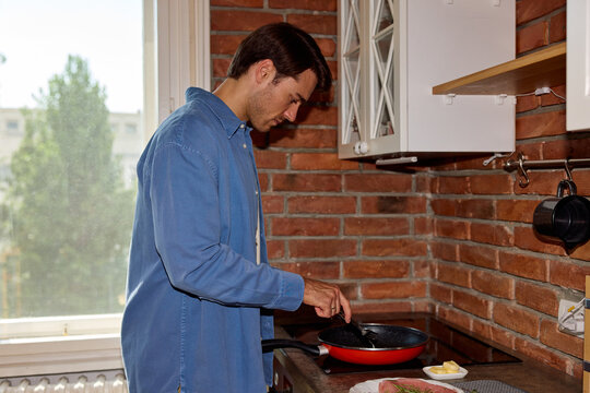 Man prepares heating up the frying pan