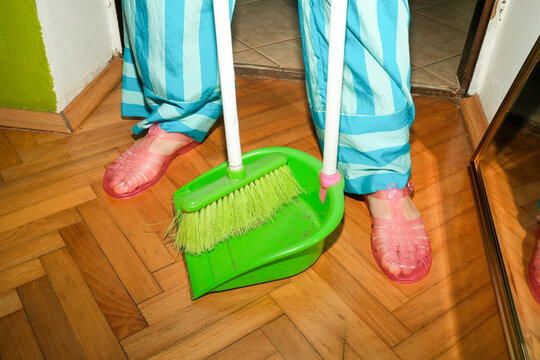 Dustpan and Broom on Wooden Floor
