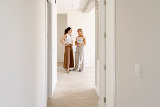 Architect and client talking in renovated apartment hallway