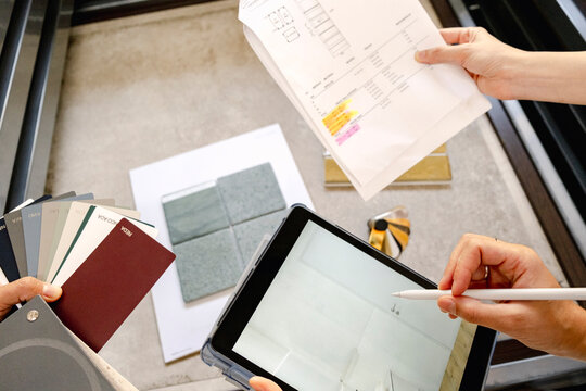 Hands planning tile layout with samples and tablet