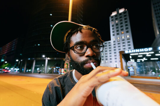 Man Drinking Milkshake at Night