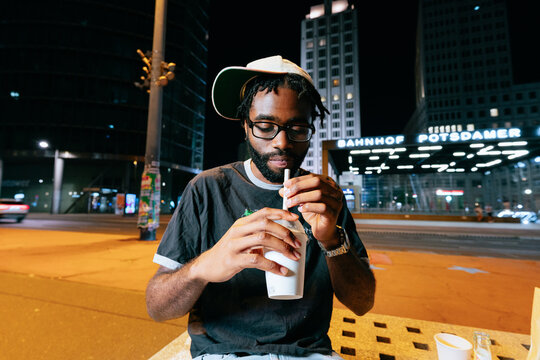 Man Drinking Milkshake at Night