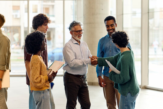 Professor shake hands with his students