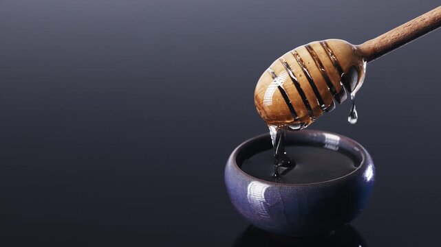 Macro Slow Motion Honey Pouring on Wooden Dipper
