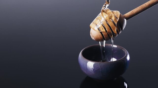 Macro Slow Motion Honey Pouring on Wooden Dipper