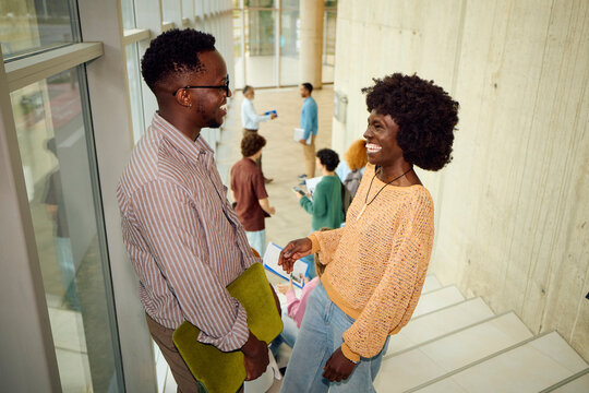 Students talking on a staircase within a building