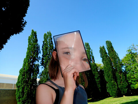 Child looking at camera through a lenticular magnifying lens