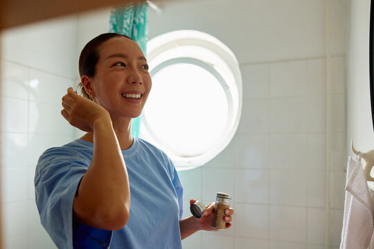Woman applies makeup in the bathroom.