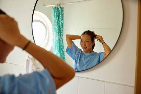 Woman prepares herself in the bathroom.