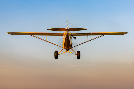 An airplane flies into the sunset