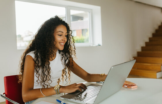 Woman Smiling While Typing Laptop