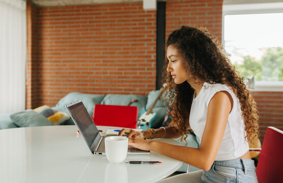 Woman Typing Laptop Near Brick Wall