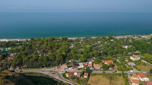 Velia Cilento Italy hidden gems 4K drone video. Panning over green coastal fields and beach revealing ancient ruins and medieval tower over sea. Scenic travel b roll stock footage