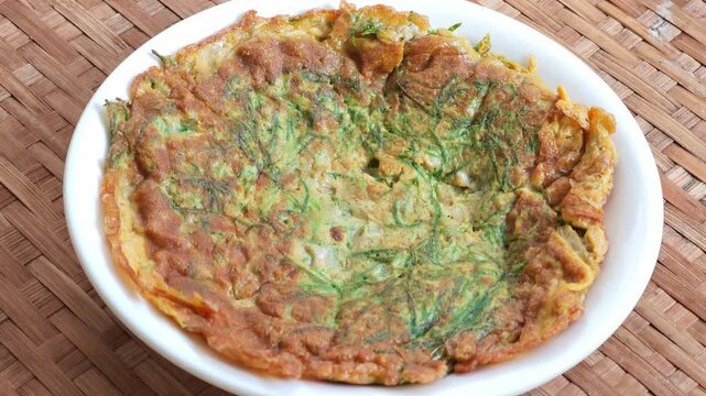 Cha-om omelet in a white plate