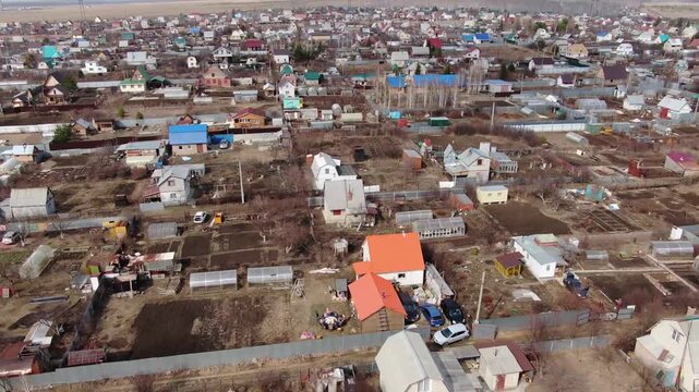 Drone glides over village rooftops and bare fields. Farms, sheds, and colorful homes stretch across the terrain. Cars sit idle along narrow roads. , so no emotions to describe