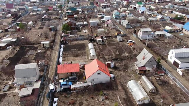 Aerial view of a quiet rural village with colorful houses. Red roofs, white walls, and dirt yards form the scene. , so emotions are not applicable