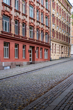 Colorful residential street in Gr&uuml;nerl&oslash;kka Oslo Norway shows historic facades and cobblestones lined with autumn leaves in a quiet urban scene