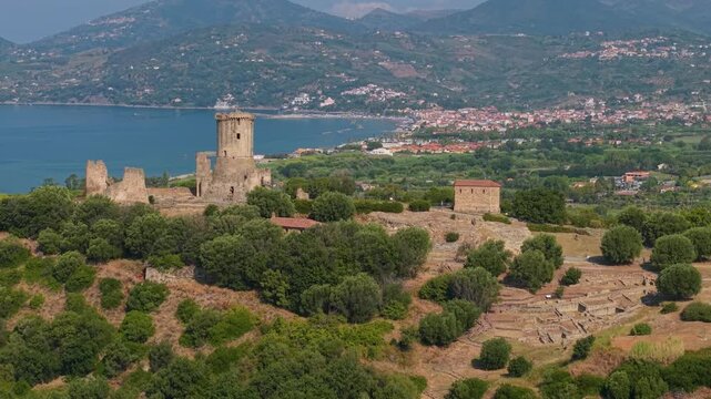 Torre di Velia Ascea Cilento Italy 4K drone video. 70mm telephoto lateral flyby of Norman watchtower and Elea archaeological ruins with sea. UNESCO heritage site