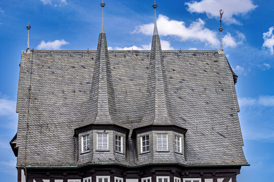 A picturesque market square with historic half-timbered houses beneath a bright blue sky; the old town with Alsfeld Town Hall