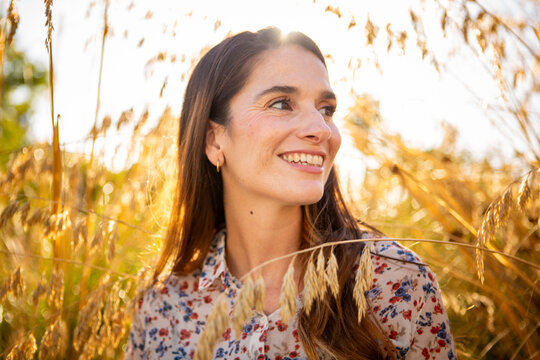 Smiling woman enjoying golden hour in nature