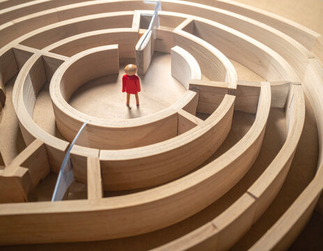 Person standing inside a circular maze seeking clear direction