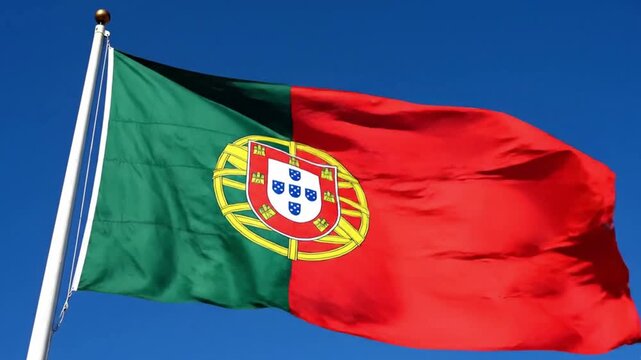 National flag of portugal waving against a clear blue sky