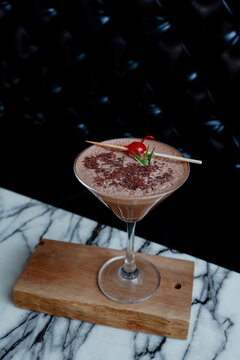 Cocoa drink and Cherry on top in wine glass,Natural craft organic healthy chocolate drink,iced chocolate drink,cacao pod,cacao nibs,space for text.