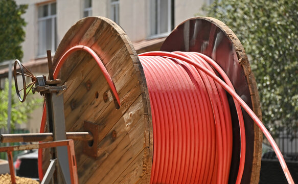 Red power electric cable on wooden reel