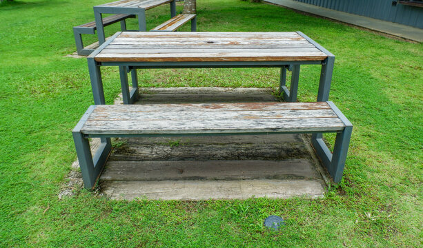 Wooden Bench in park,chairs and table in countryside,outdoor seating cafe or restaurant,Neat paved patio with sitting area,small garden in farm.